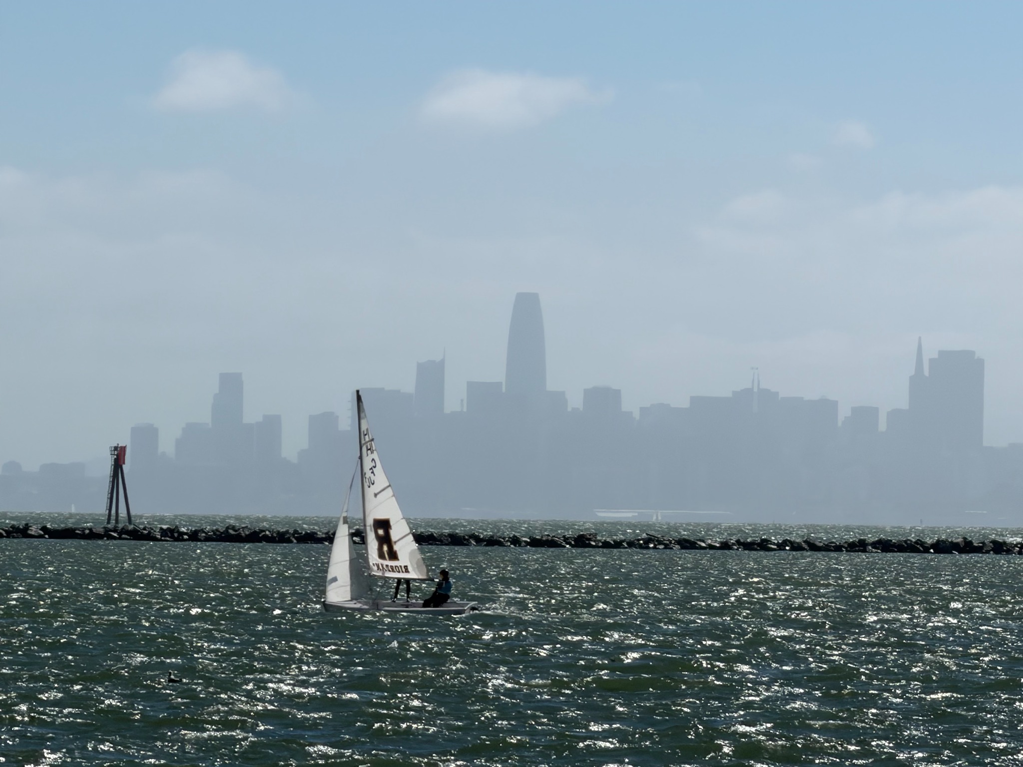 Riordan’s R sail on San Francisco Bay with the city skyline in the distance